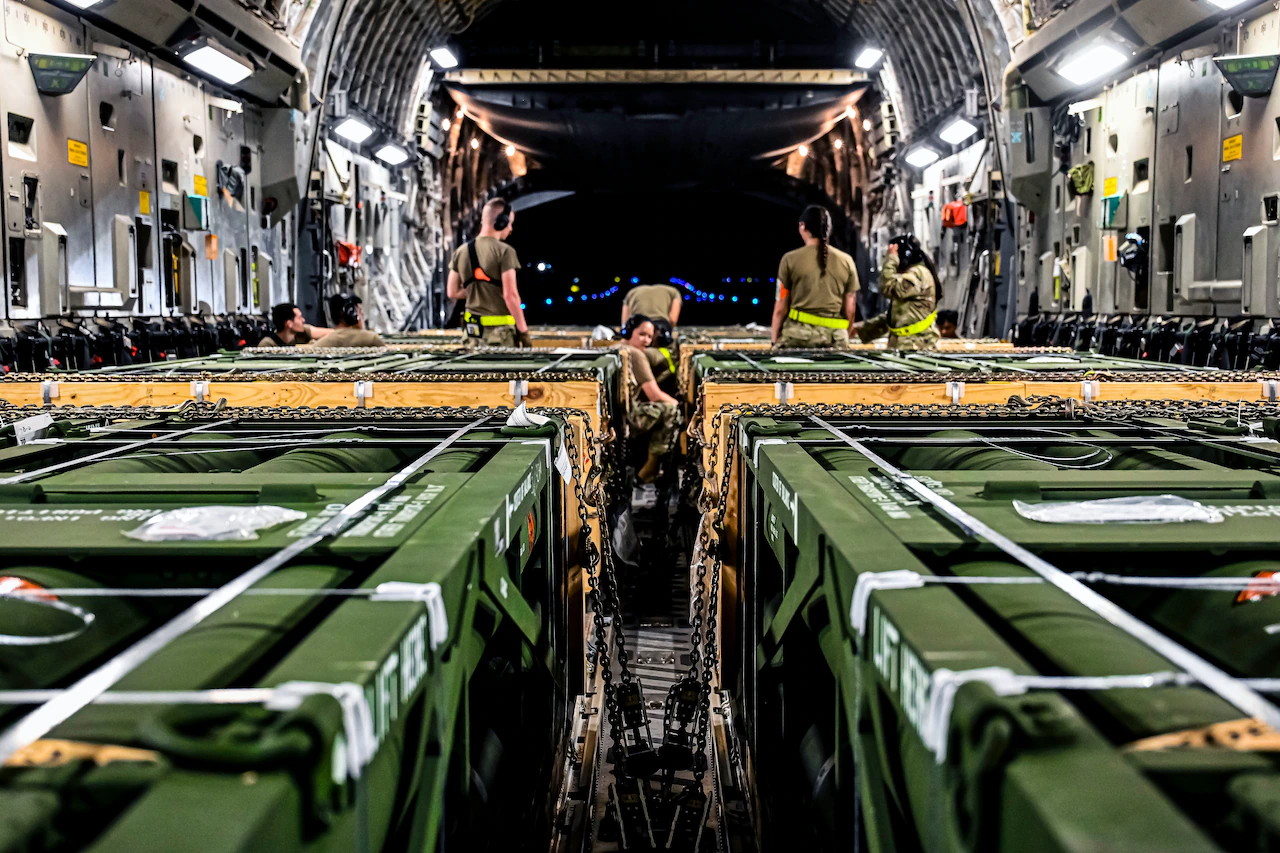 Летчики, приписанные к 305-й эскадрилье авиапорта, загружают боеприпасы управляемой реактивной системы залпового огня в Боинг-767 на объединенной базе Макгуайр-Дикс-Лейкхерст, штат Нью-Джерси, 13 августа 2022 года. Груз боеприпасов является частью дополнительного пакета в области вооружения Украины.